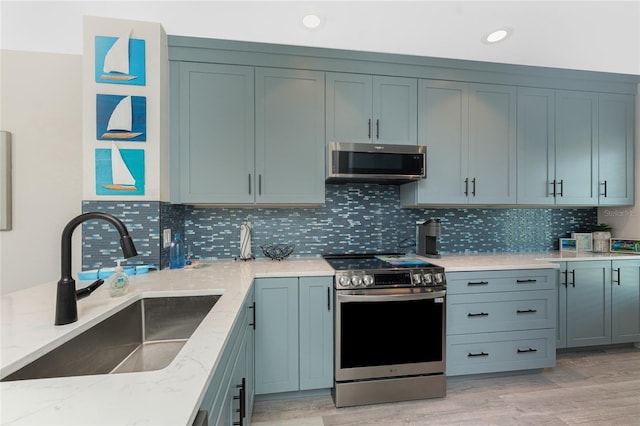 8405 Placida Rd Unit 406, Placida, FL 33946 - kitchen with appliances with stainless steel finishes, a sink, light stone countertops, decorative backsplash, and recessed lighting