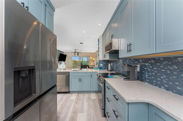 8405 Placida Rd Unit 406, Placida, FL 33946 - kitchen with stainless steel appliances, light stone counters, tasteful backsplash, a sink, and light wood finished floors