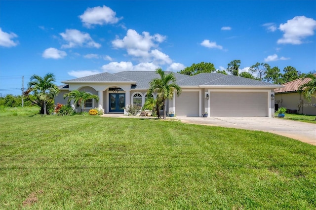 423 Boundary Blvd, Rotonda West, FL 33947 - view of front of house with french doors, a garage, driveway, a front yard, and stucco siding