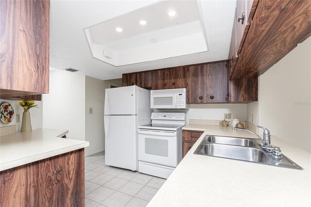 1337 Le Pera Rd, Englewood, FL 34223 - kitchen featuring white appliances, a sink, light countertops, light tile patterned floors, and a raised ceiling
