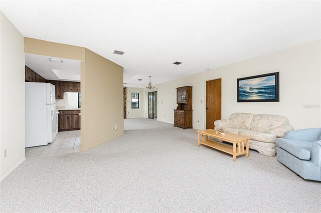 1337 Le Pera Rd, Englewood, FL 34223 - living room with light carpet, a chandelier, light tile patterned floors, and baseboards