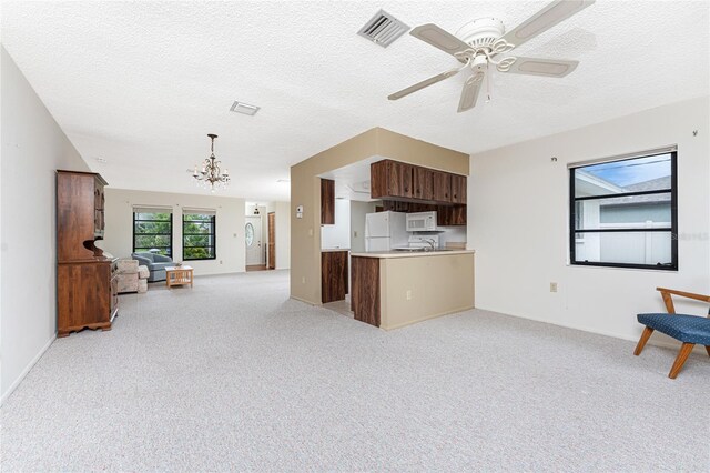 1337 Le Pera Rd, Englewood, FL 34223 - kitchen featuring white appliances, open floor plan, a chandelier, light carpet, and a textured ceiling