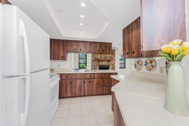1337 Le Pera Rd, Englewood, FL 34223 - kitchen featuring white appliances, light countertops, a fireplace, light tile patterned floors, and a raised ceiling