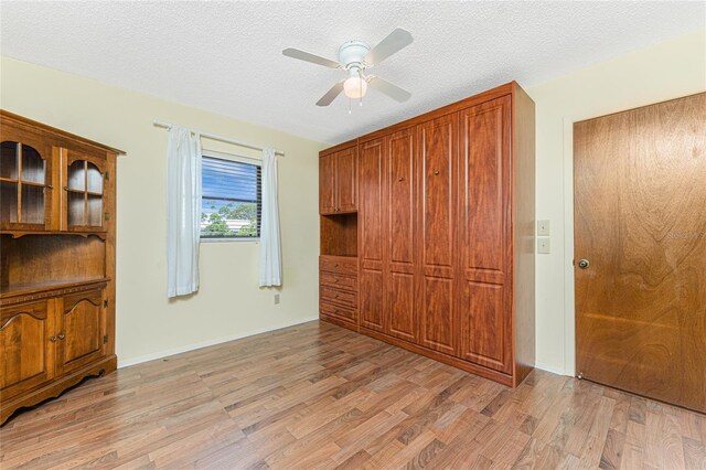 1337 Le Pera Rd, Englewood, FL 34223 - unfurnished bedroom with light wood-style floors, a textured ceiling, and ceiling fan