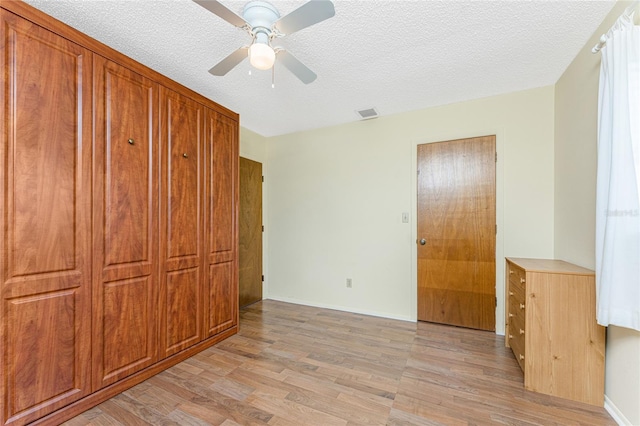 1337 Le Pera Rd, Englewood, FL 34223 - unfurnished bedroom with light wood-style flooring, a textured ceiling, ceiling fan, and baseboards