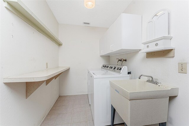 1337 Le Pera Rd, Englewood, FL 34223 - washroom featuring washing machine and dryer, cabinet space, light tile patterned floors, a textured ceiling, and baseboards