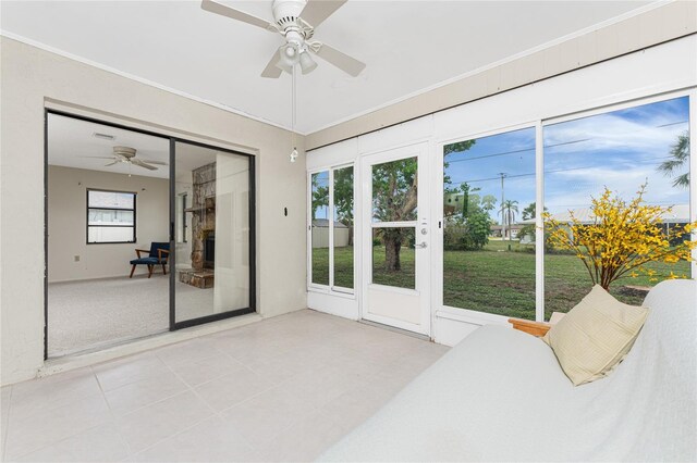 1337 Le Pera Rd, Englewood, FL 34223 - unfurnished bedroom with access to exterior, ceiling fan, a fireplace with raised hearth, a closet, and ornamental molding