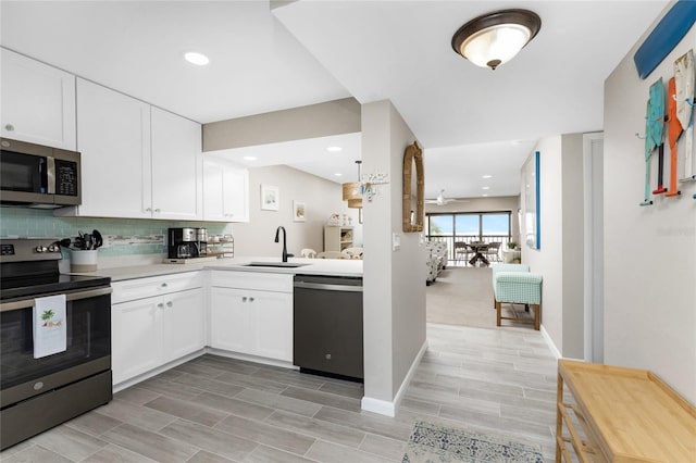 1591 Beach Rd Unit 402, Englewood, FL 34223 - kitchen featuring appliances with stainless steel finishes, light countertops, backsplash, white cabinetry, and recessed lighting