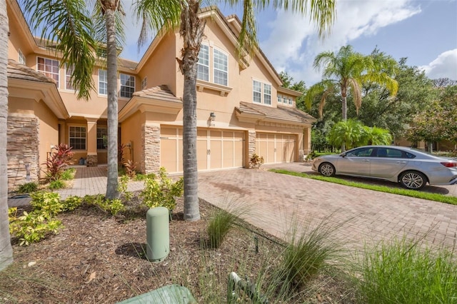 8228 Villa Grande Ct, Sarasota, FL 34243 - view of front of home with an attached garage, driveway, stucco siding, and stone siding