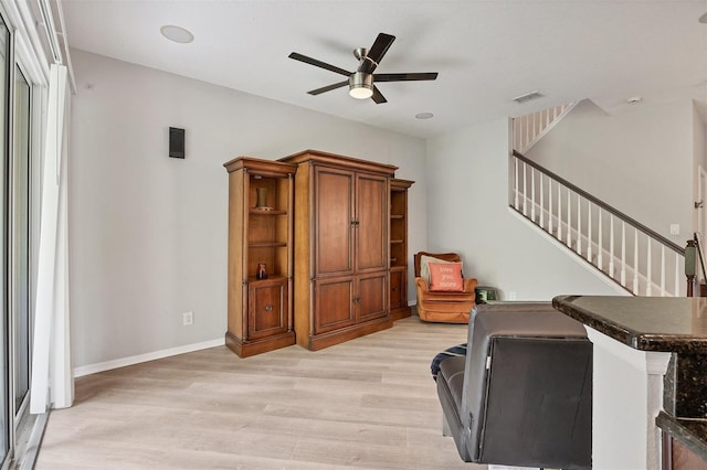 8228 Villa Grande Ct, Sarasota, FL 34243 - living room with light wood finished floors, ceiling fan, stairway, and baseboards