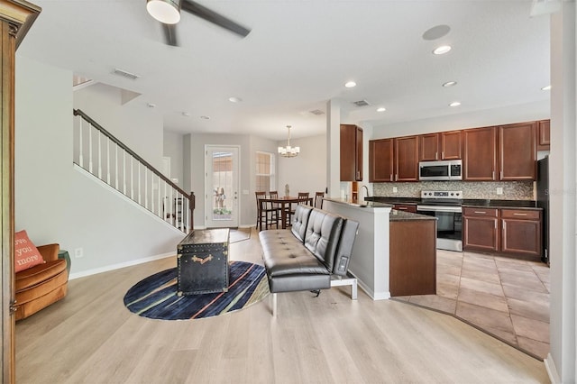 8228 Villa Grande Ct, Sarasota, FL 34243 - living area featuring stairway, a ceiling fan, light wood-style flooring, recessed lighting, and a chandelier