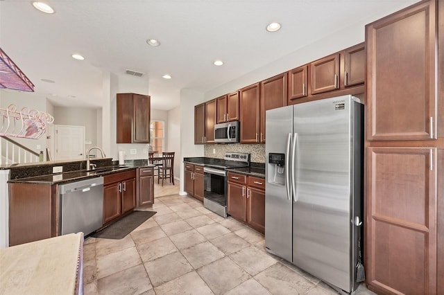 8228 Villa Grande Ct, Sarasota, FL 34243 - kitchen featuring stainless steel appliances, a sink, recessed lighting, dark stone countertops, and a peninsula