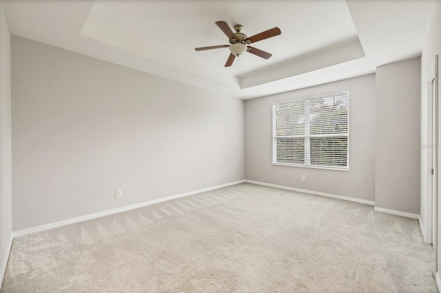 8228 Villa Grande Ct, Sarasota, FL 34243 - unfurnished room with light carpet, a tray ceiling, and baseboards