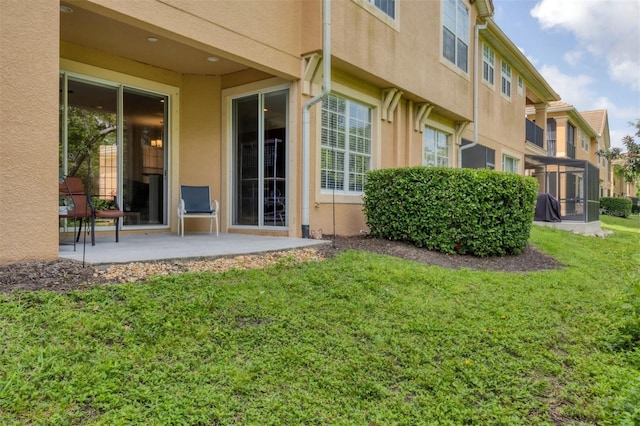 8228 Villa Grande Ct, Sarasota, FL 34243 - rear view of property featuring a patio area, stucco siding, and a lawn