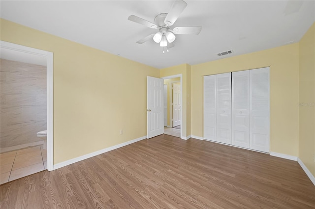 4371 Tollefson Ave, North Port, FL 34287 - unfurnished bedroom featuring wood finished floors, baseboards, a closet, connected bathroom, and a ceiling fan