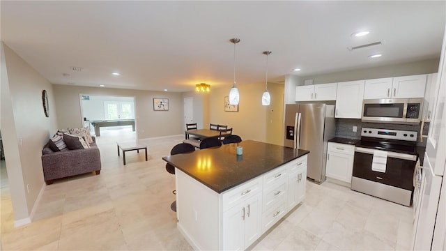 608 Saint Judes Dr, Longboat Key, FL 34228 - kitchen featuring stainless steel appliances, open floor plan, white cabinets, a center island, and recessed lighting
