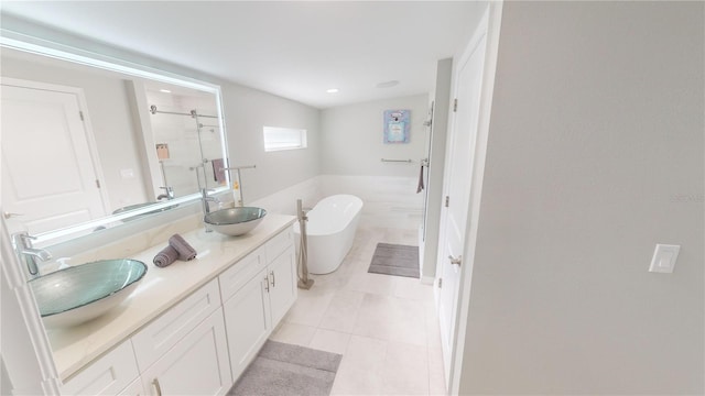 608 Saint Judes Dr, Longboat Key, FL 34228 - bathroom featuring a stall shower, double vanity, a freestanding tub, and tile patterned floors