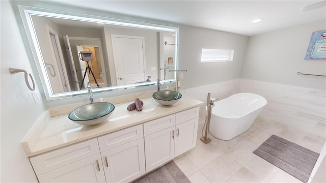 608 Saint Judes Dr, Longboat Key, FL 34228 - full bath with vanity, a freestanding bath, a wainscoted wall, and tile patterned flooring