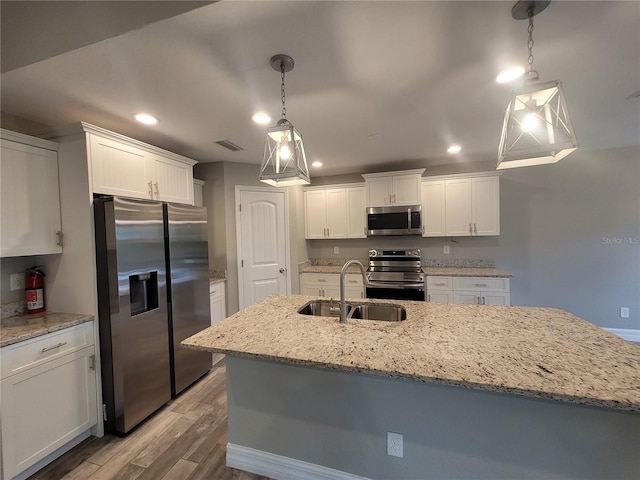 134 Swan Dr, Rotonda West, FL 33947 - kitchen with appliances with stainless steel finishes, white cabinetry, light wood-style floors, and recessed lighting