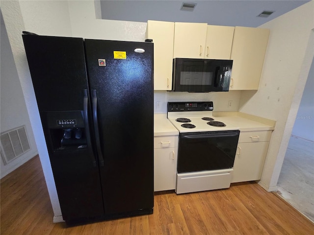 4900 Hurley Ave, North Port, FL 34288 - kitchen with black appliances, light wood-style flooring, and light countertops