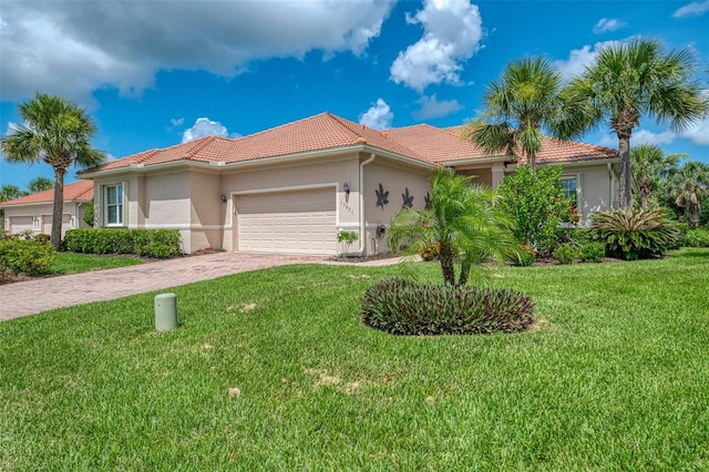 13051 Creekside Ln, Port Charlotte, FL 33953 - mediterranean / spanish home with a garage, a tiled roof, stucco siding, driveway, and a front yard