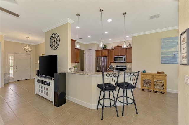 13051 Creekside Ln, Port Charlotte, FL 33953 - kitchen featuring stainless steel appliances, brown cabinets, light tile patterned flooring, a peninsula, and a kitchen breakfast bar