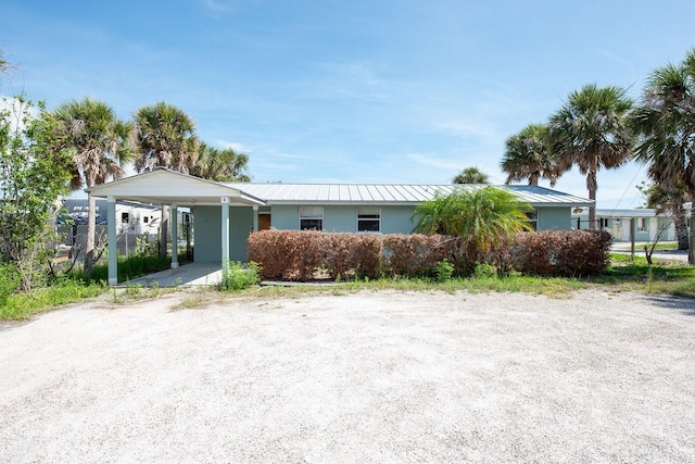 1765 Manor Rd, Englewood, FL 34223 - single story home featuring a carport, stucco siding, and a metal roof