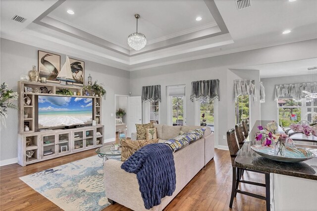 124 Cutlass Dr, Rotonda West, FL 33947 - living room featuring a tray ceiling, wood finished floors, crown molding, a chandelier, and recessed lighting