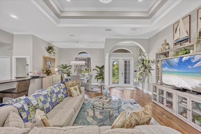 124 Cutlass Dr, Rotonda West, FL 33947 - living area with a tray ceiling, wood finished floors, arched walkways, and crown molding