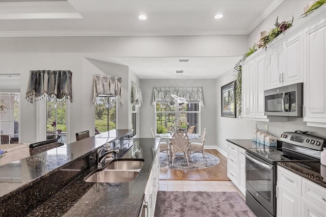 124 Cutlass Dr, Rotonda West, FL 33947 - kitchen with stainless steel appliances, dark stone countertops, light tile patterned floors, white cabinetry, and recessed lighting