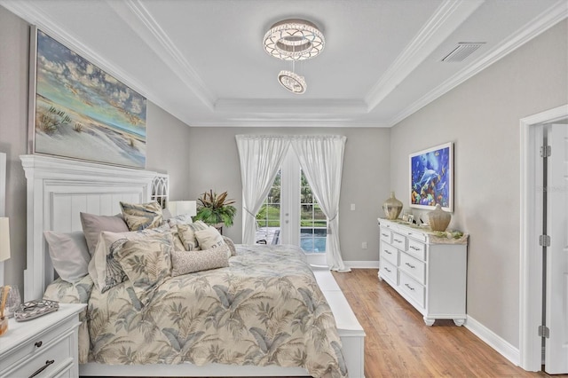 124 Cutlass Dr, Rotonda West, FL 33947 - bedroom featuring access to exterior, a raised ceiling, light wood-type flooring, french doors, and crown molding