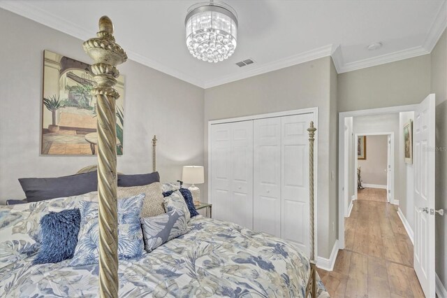 124 Cutlass Dr, Rotonda West, FL 33947 - bedroom featuring hardwood / wood-style flooring, a chandelier, crown molding, and a closet