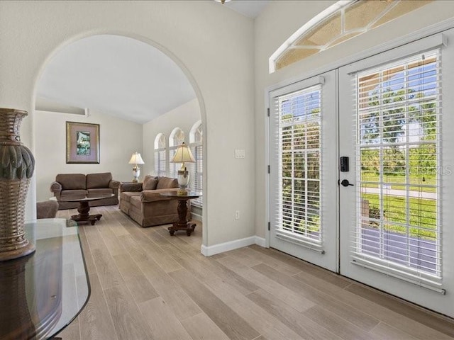 23 Pine Valley Ct, Rotonda West, FL 33947 - doorway to outside featuring french doors, arched walkways, wood finished floors, and vaulted ceiling