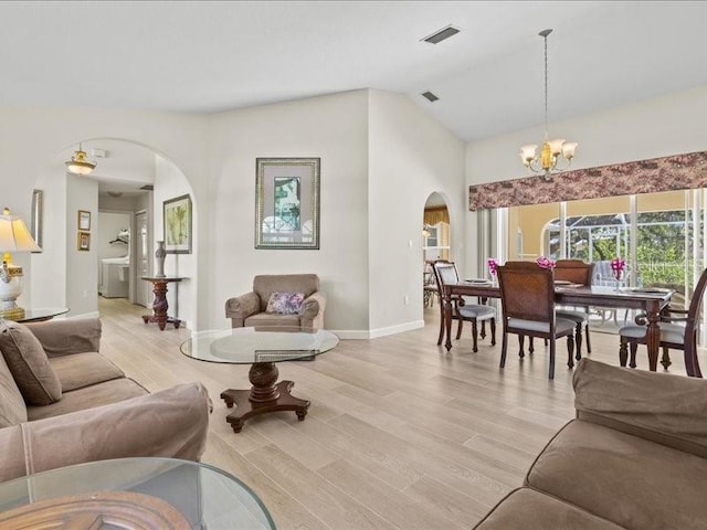 23 Pine Valley Ct, Rotonda West, FL 33947 - living room featuring arched walkways, light wood-type flooring, a chandelier, and high vaulted ceiling