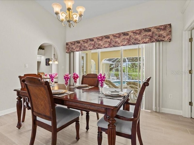 23 Pine Valley Ct, Rotonda West, FL 33947 - dining space featuring a chandelier, light wood finished floors, and arched walkways