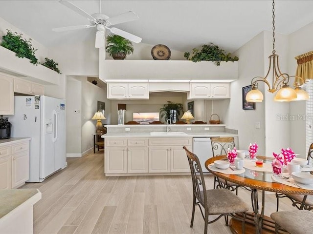 23 Pine Valley Ct, Rotonda West, FL 33947 - kitchen featuring white appliances, light countertops, light wood-style flooring, white cabinetry, and a ceiling fan