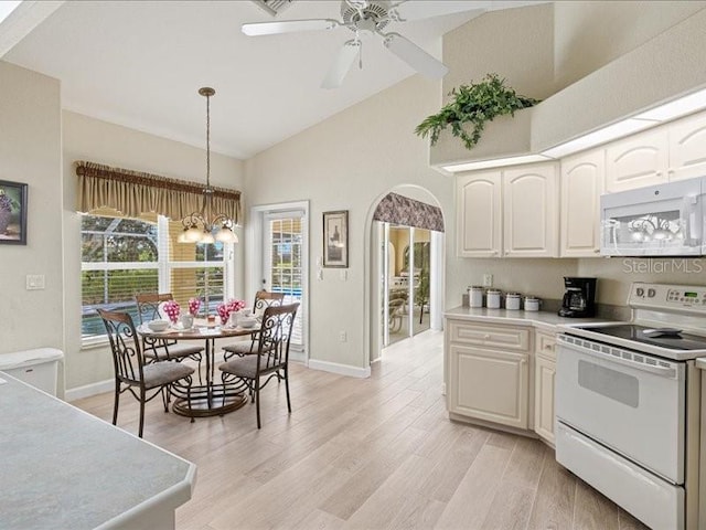 23 Pine Valley Ct, Rotonda West, FL 33947 - kitchen with white appliances, arched walkways, light wood finished floors, light countertops, and pendant lighting