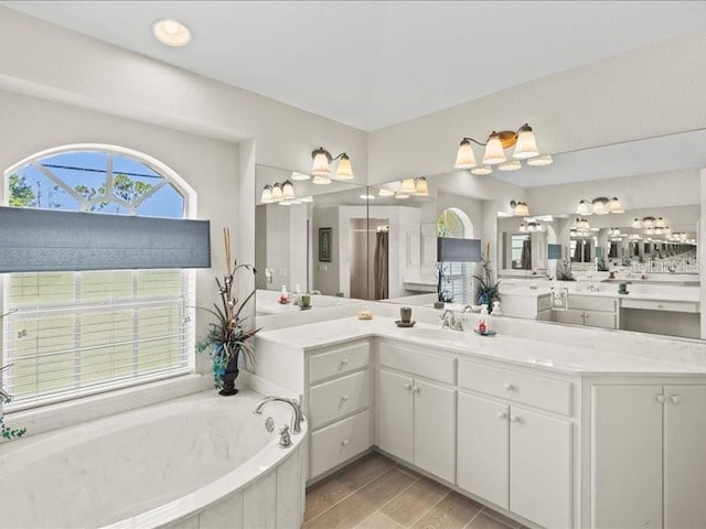 23 Pine Valley Ct, Rotonda West, FL 33947 - full bathroom featuring a garden tub, vanity, and wood finished floors