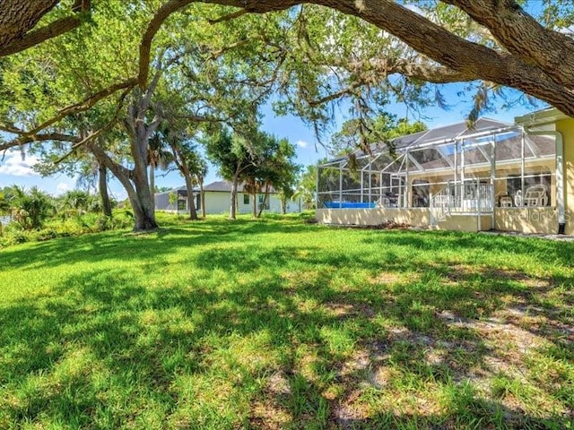 23 Pine Valley Ct, Rotonda West, FL 33947 - view of green lawn with a lanai