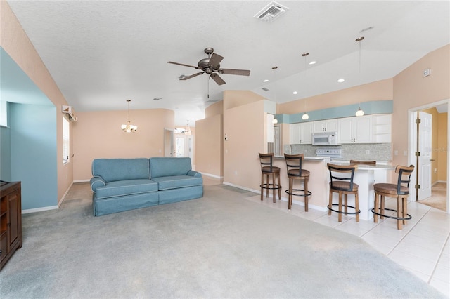 127 Jennifer Dr, Rotonda West, FL 33947 - living room featuring vaulted ceiling, a ceiling fan, a chandelier, recessed lighting, and light colored carpet