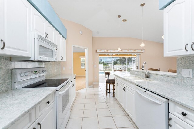 127 Jennifer Dr, Rotonda West, FL 33947 - kitchen featuring white appliances, lofted ceiling, backsplash, and white cabinetry