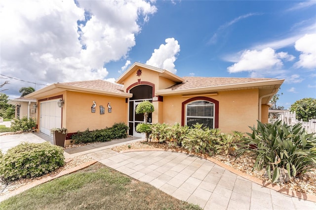 127 Jennifer Dr, Rotonda West, FL 33947 - mediterranean / spanish-style house featuring stucco siding, a garage, driveway, and a shingled roof
