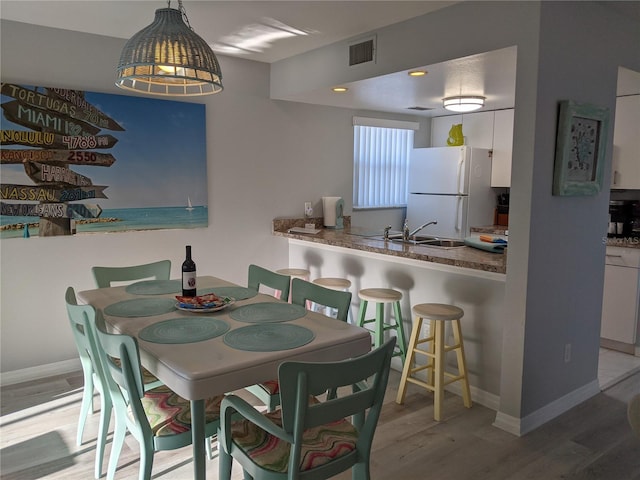 2373 N Beach Rd Unit 1C, Englewood, FL 34223 - dining area featuring light wood-type flooring and baseboards
