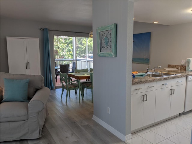 2373 N Beach Rd Unit 1C, Englewood, FL 34223 - kitchen featuring white cabinets, light wood-style flooring, and dishwashing machine