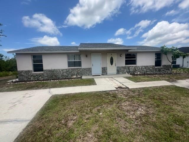 11216 Kimberly Ave Unit A & B, Englewood, FL 34224 - single story home with stucco siding, stone siding, and a front lawn