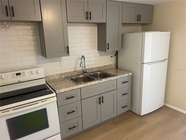 11216 Kimberly Ave Unit A & B, Englewood, FL 34224 - kitchen with white appliances, gray cabinets, tasteful backsplash, and light wood-style floors