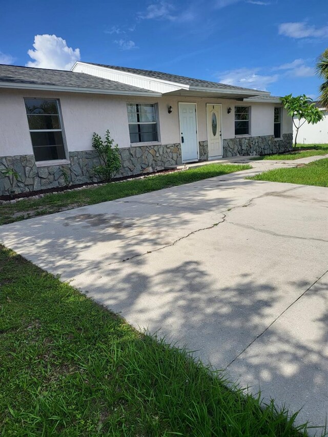 11216 Kimberly Ave Unit A & B, Englewood, FL 34224 - view of front of house featuring stone siding, stucco siding, and a front yard