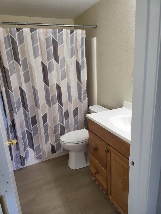 11216 Kimberly Ave Unit A & B, Englewood, FL 34224 - full bath featuring a textured wall, wood finished floors, vanity, and curtained shower