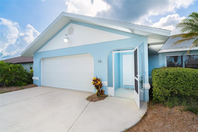 15 Bunker Pl, Rotonda West, FL 33947 - view of front of house featuring stucco siding, a garage, and driveway