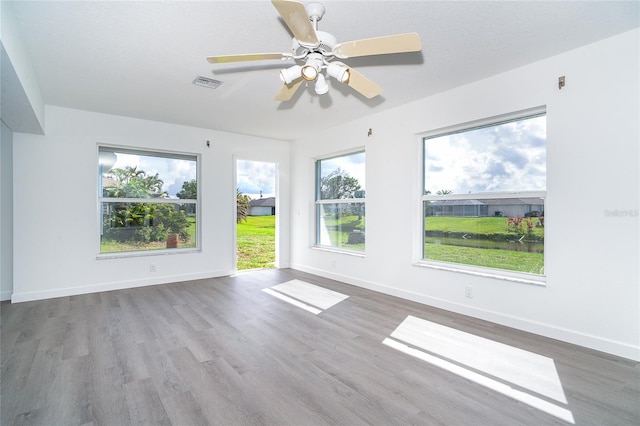 15 Bunker Pl, Rotonda West, FL 33947 - empty room with wood finished floors, plenty of natural light, and ceiling fan